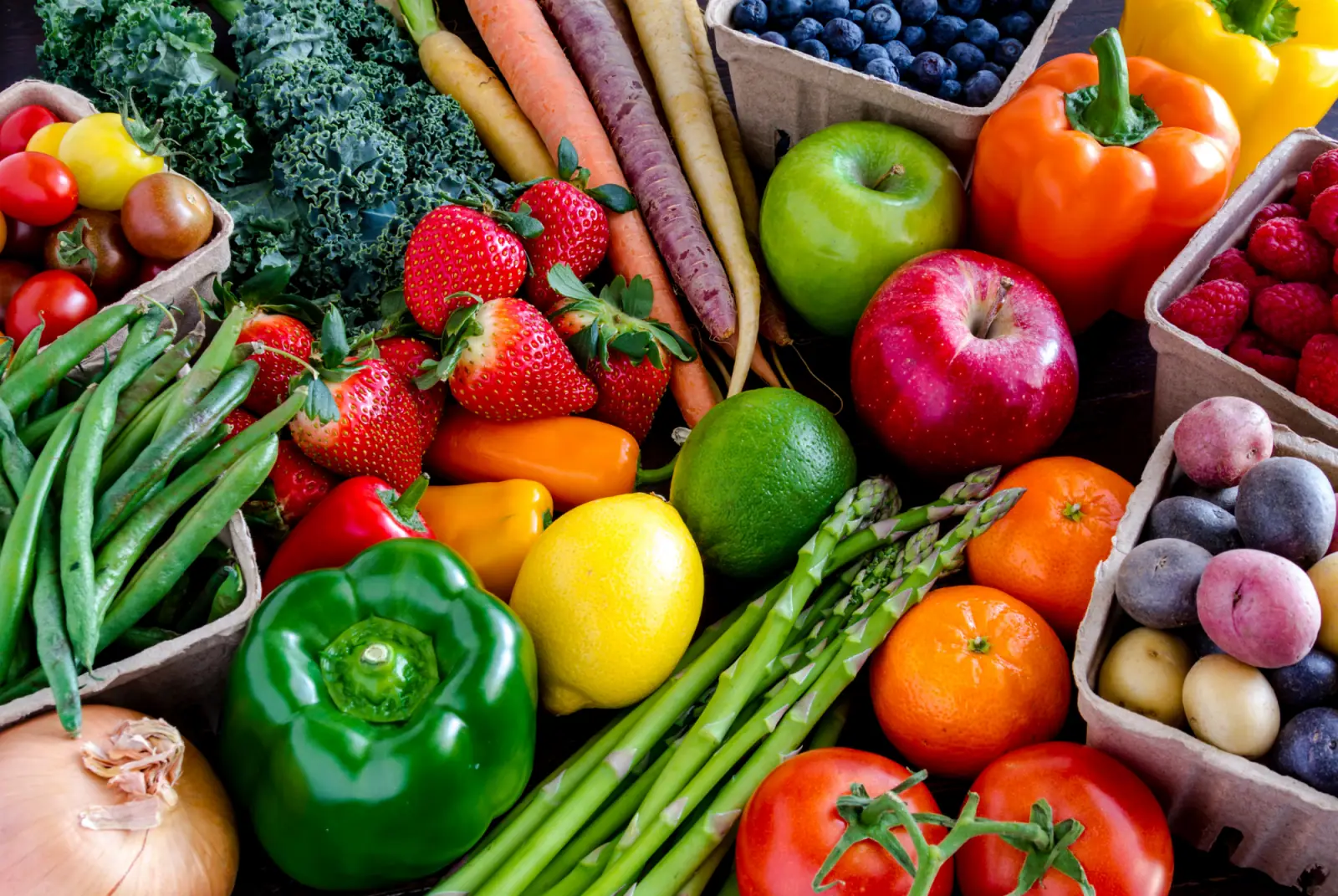 Bunte Auswahl an frischem Obst und Gemüse wie Paprika, Tomaten, Erdbeeren, Äpfeln, Karotten und Spargel