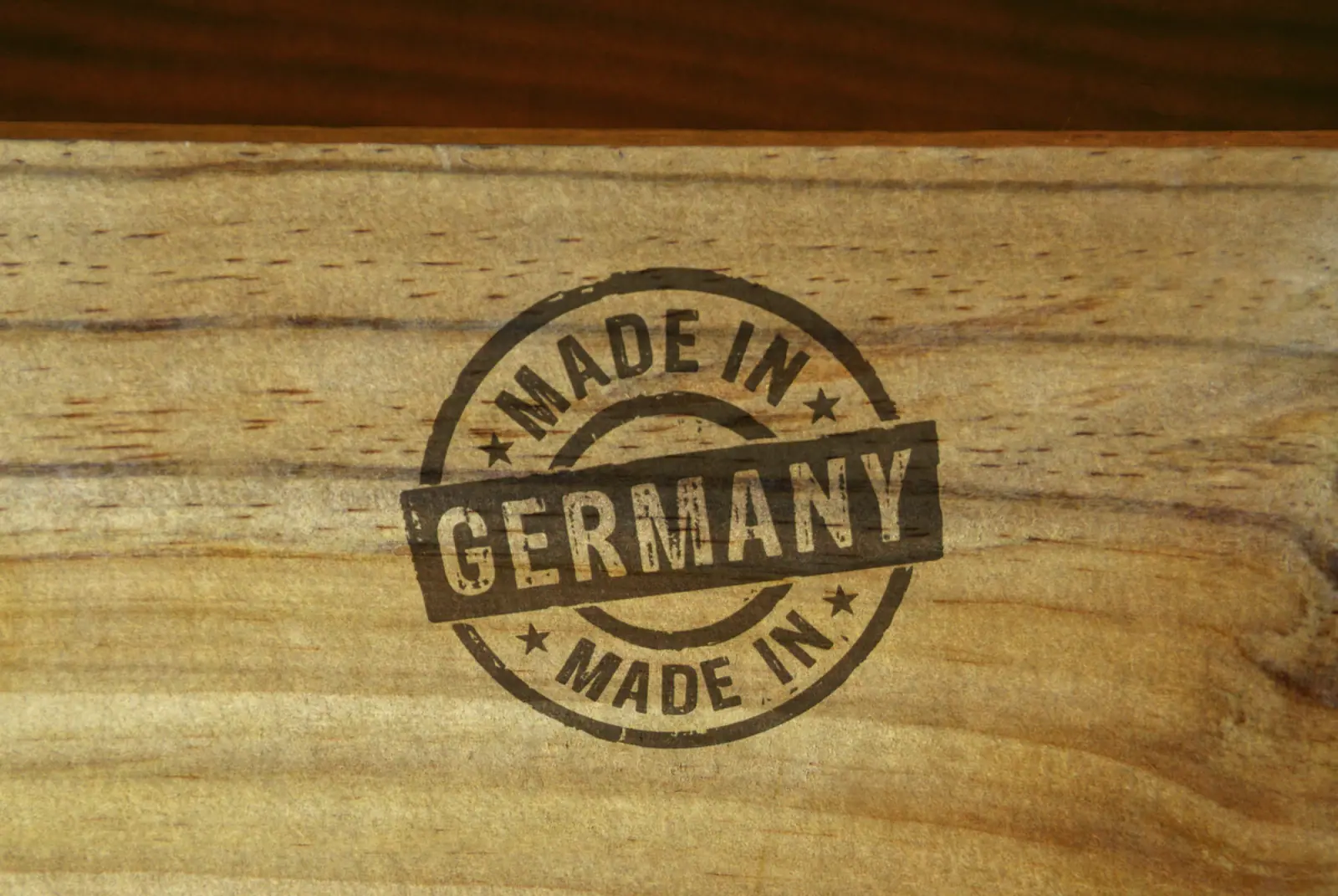 Stempel mit der Aufschrift „MADE IN GERMANY“ auf einer hellen Holzoberfläche mit Maserung