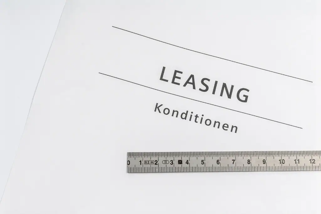 Weißes Blatt Papier mit dem Schriftzug LEASING Konditionen und einem Lineal aus Metall