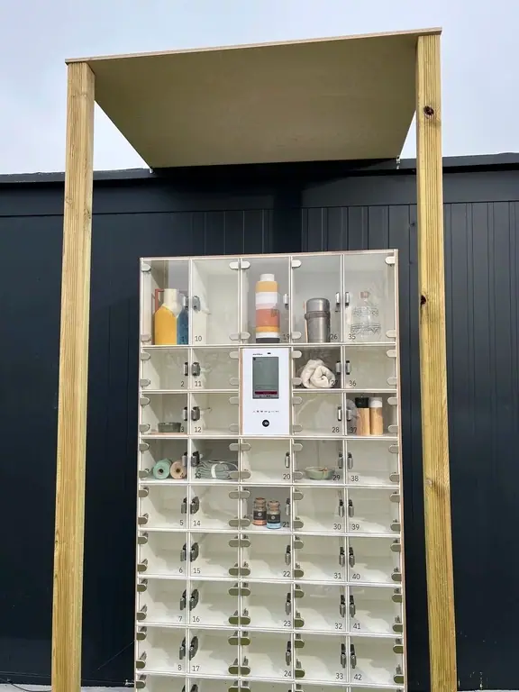 Witte marktbox met glazen vakken onder een beschermende houtconstructie voor een donkere muur