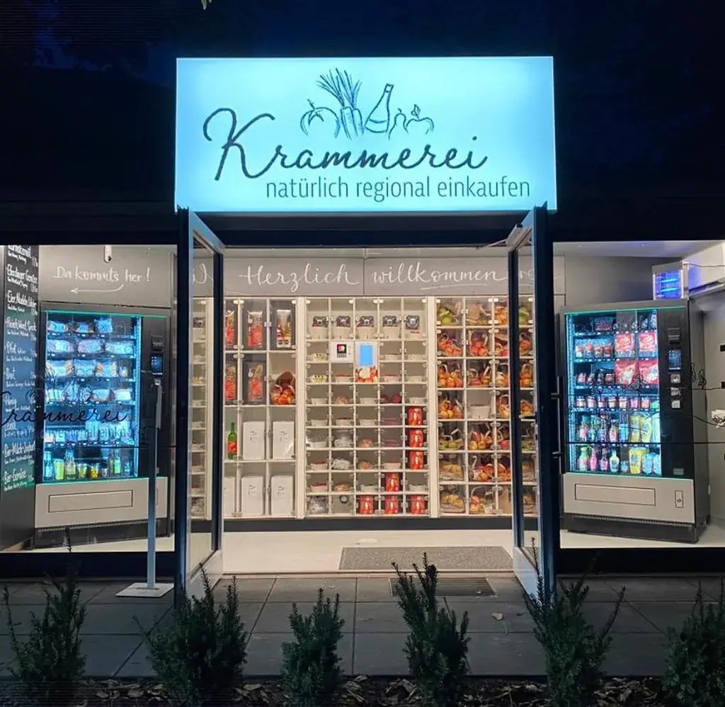Hell erleuchteter Automaten-Kiosk mit regionalen Produkten in modernen Verkaufsautomaten und Glasfächern bei Nacht