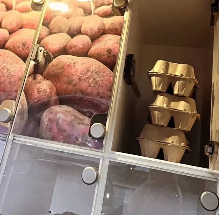 Æggebakker og kartofler i rummene på en salgsautomat